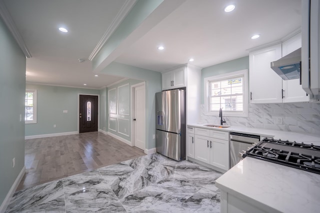 115-42 Inwood St, Jamaica, NY 11436 - kitchen featuring appliances with stainless steel finishes, crown molding, a sink, under cabinet range hood, and white cabinets