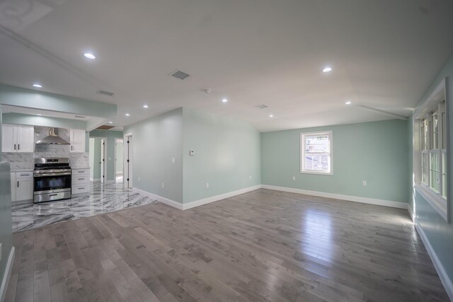 115-42 Inwood St, Jamaica, NY 11436 - unfurnished living room featuring wood finished floors, baseboards, lofted ceiling, and recessed lighting