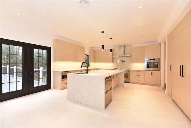 kitchen with pendant lighting, light brown cabinets, stainless steel appliances, and french doors