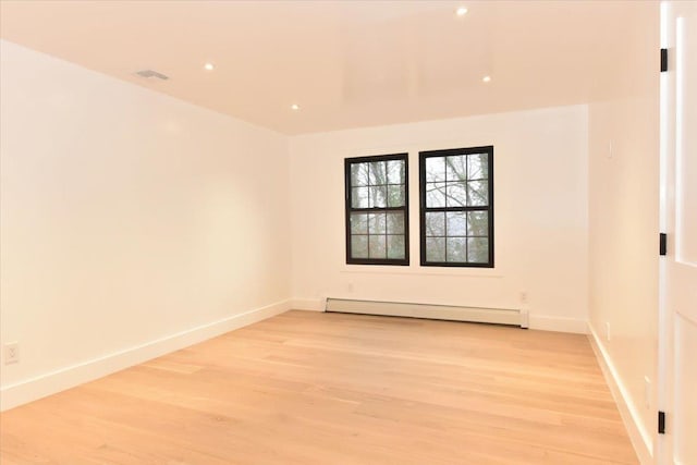 spare room with light hardwood / wood-style floors and a baseboard heating unit