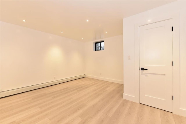 spare room featuring light hardwood / wood-style floors and a baseboard heating unit