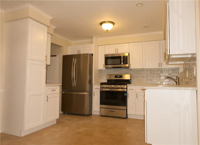 kitchen featuring white cabinets, appliances with stainless steel finishes, ornamental molding, and sink