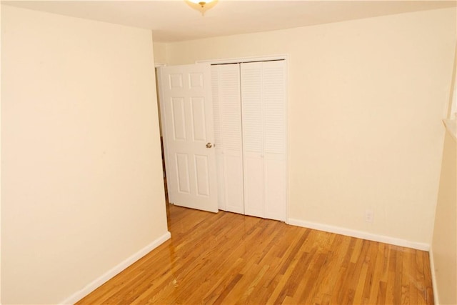 unfurnished bedroom with light hardwood / wood-style floors and a closet