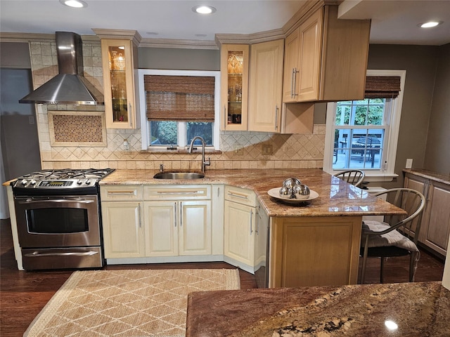 kitchen featuring sink, stainless steel gas range, wall chimney exhaust hood, dark hardwood / wood-style floors, and light stone countertops