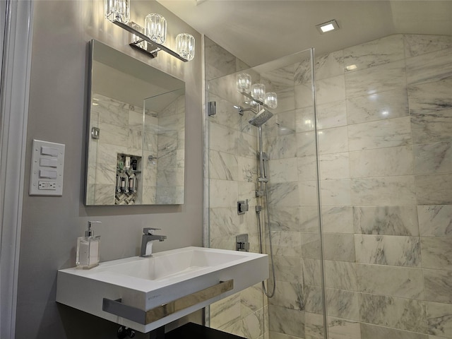 bathroom with a tile shower and sink