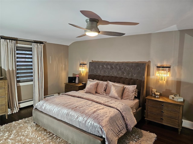 bedroom with dark hardwood / wood-style floors, ceiling fan, and a baseboard heating unit