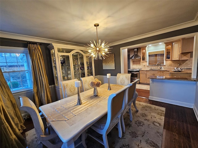 dining area with a chandelier, dark hardwood / wood-style floors, ornamental molding, and sink