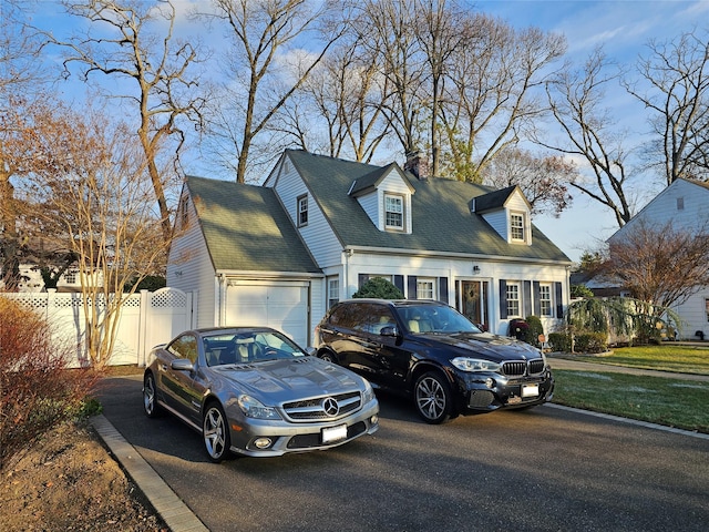 cape cod home with a garage