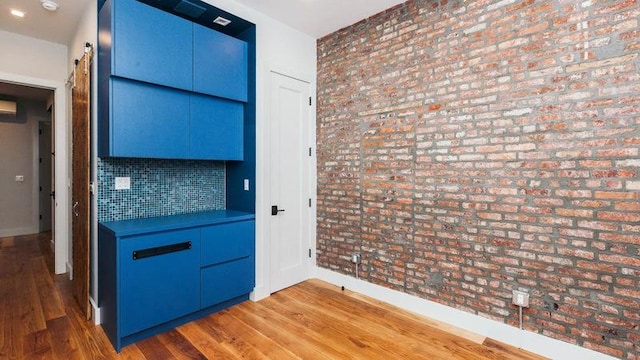 kitchen featuring blue cabinetry, decorative backsplash, and wood finished floors