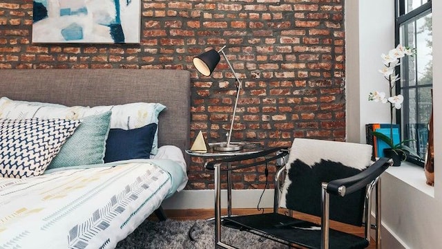 living area with brick wall and baseboards