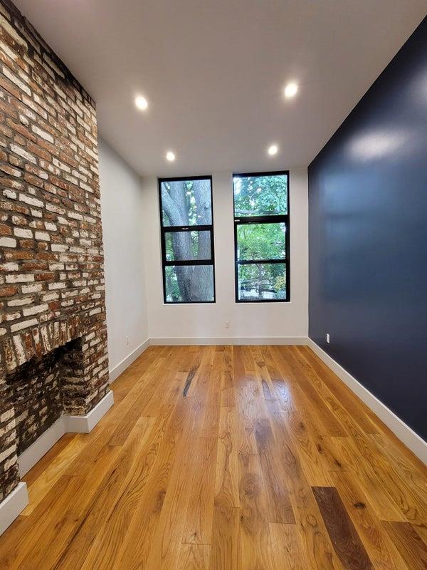 empty room featuring recessed lighting, baseboards, a fireplace, and light wood finished floors