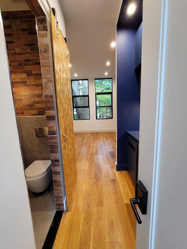 corridor with a barn door, recessed lighting, and light wood-style floors