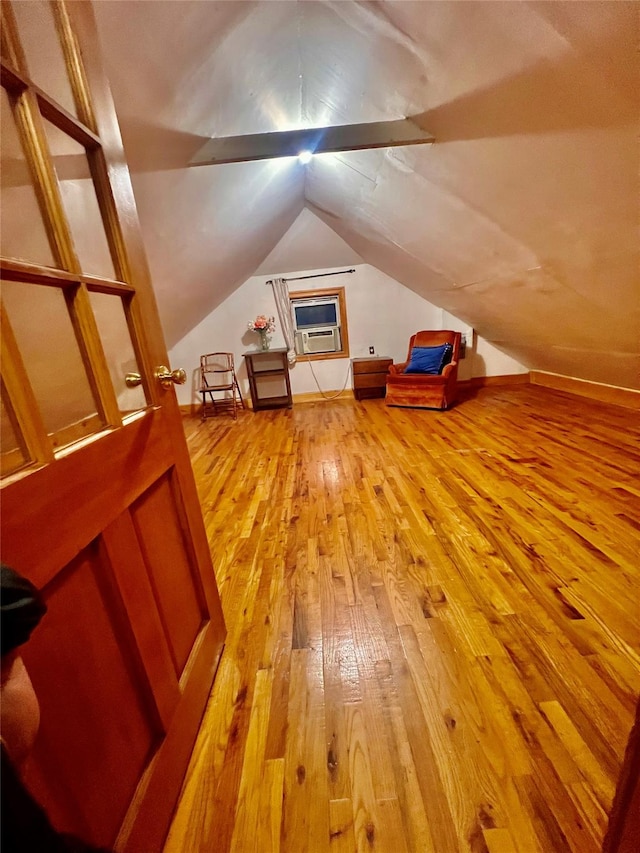 additional living space featuring light hardwood / wood-style floors and lofted ceiling