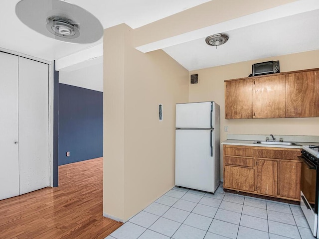 kitchen featuring white appliances, light hardwood / wood-style flooring, and sink