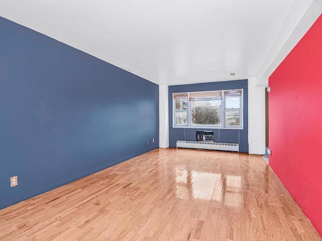 unfurnished living room with light wood-type flooring and baseboard heating