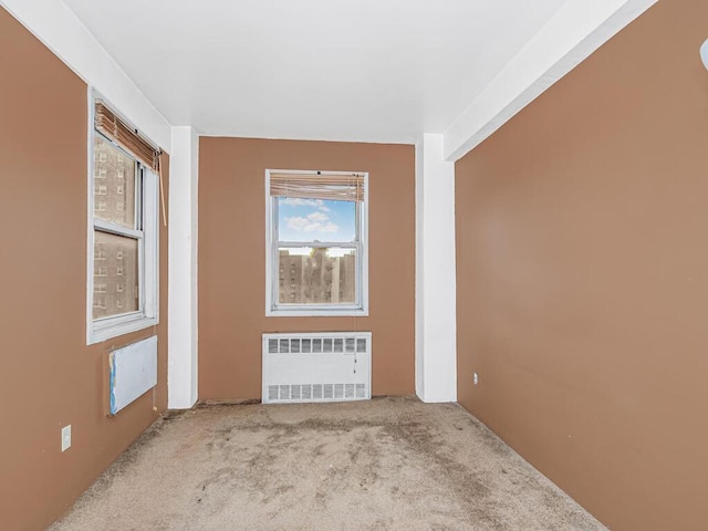 carpeted spare room featuring radiator heating unit