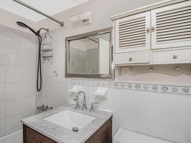 bathroom with vanity, toilet, and tile walls