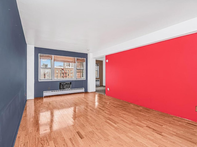 unfurnished living room featuring baseboard heating, radiator heating unit, and wood-type flooring