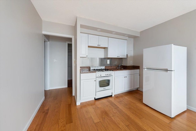 kitchen with white cabinetry, white appliances, sink, and light hardwood / wood-style flooring