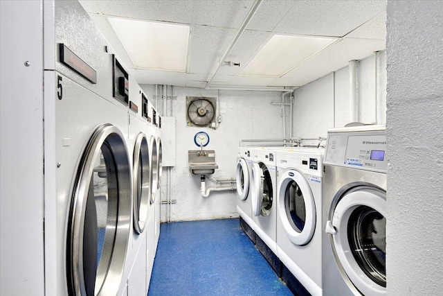 clothes washing area featuring washer and clothes dryer and sink