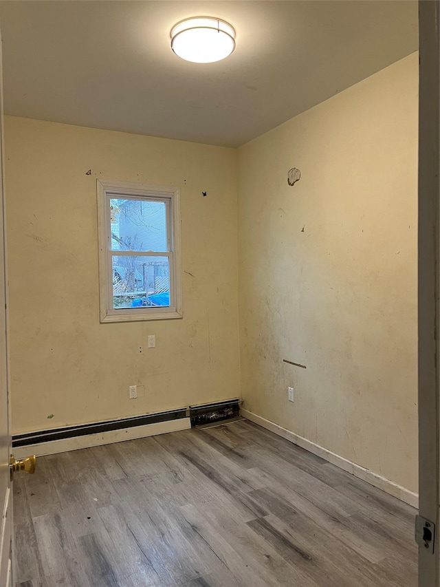 empty room featuring light hardwood / wood-style flooring and a baseboard heating unit