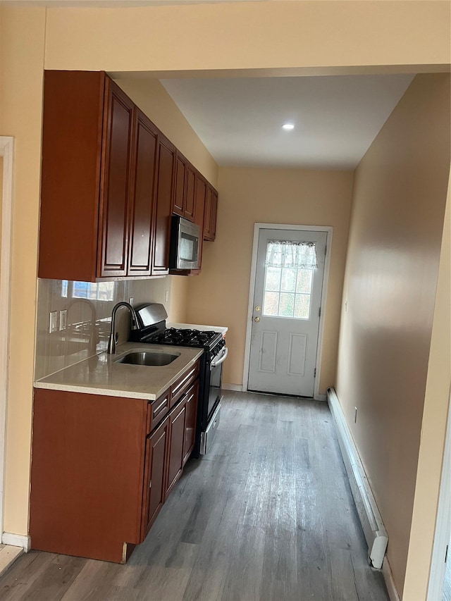 88 Taft Ave, Staten Island, NY 10301 - kitchen featuring stainless steel microwave, gas stove, light wood finished floors, light countertops, and a baseboard radiator