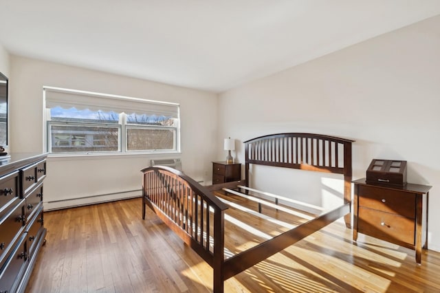 bedroom featuring light wood-type flooring and a baseboard radiator