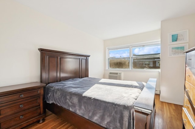 bedroom featuring a wall unit AC and wood-type flooring