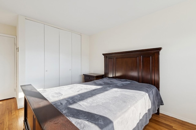 bedroom with light wood-type flooring and a closet