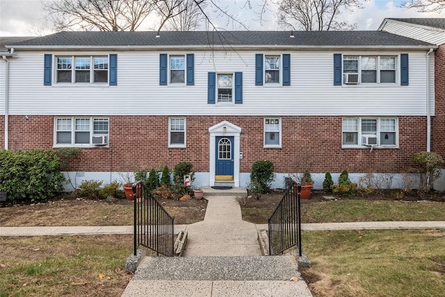 view of front of house with a front yard and cooling unit