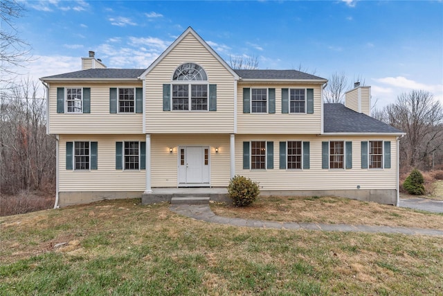 colonial home featuring a front lawn