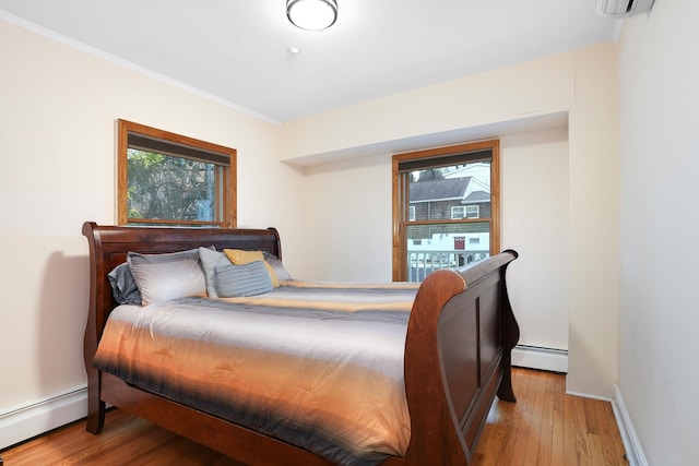 bedroom featuring light hardwood / wood-style flooring and a baseboard heating unit