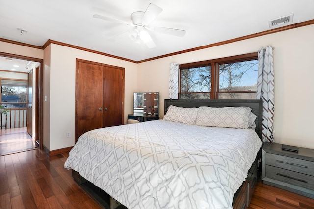 bedroom featuring dark hardwood / wood-style flooring, ceiling fan, a closet, and multiple windows