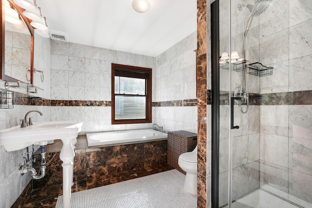 full bathroom with sink, plus walk in shower, tile patterned floors, toilet, and tile walls