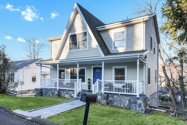 view of front of property with covered porch and a front yard