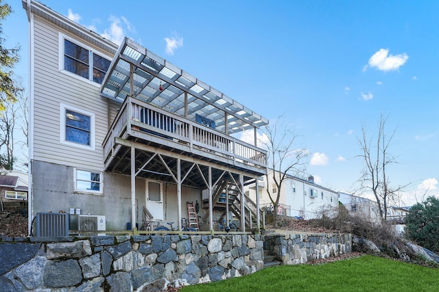 rear view of property featuring central AC unit and a deck