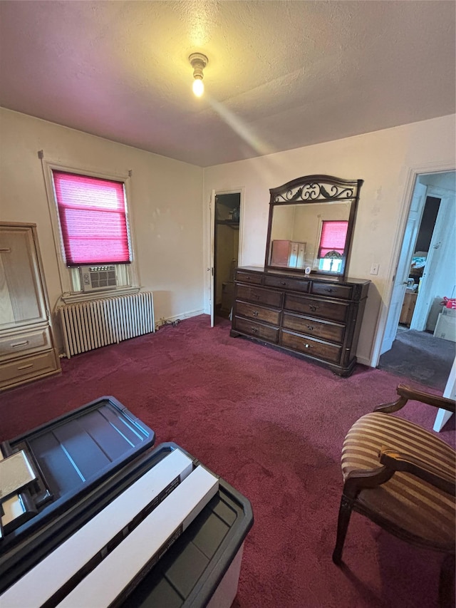 carpeted bedroom featuring a textured ceiling and radiator heating unit