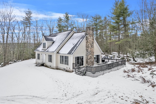 snow covered rear of property featuring a deck