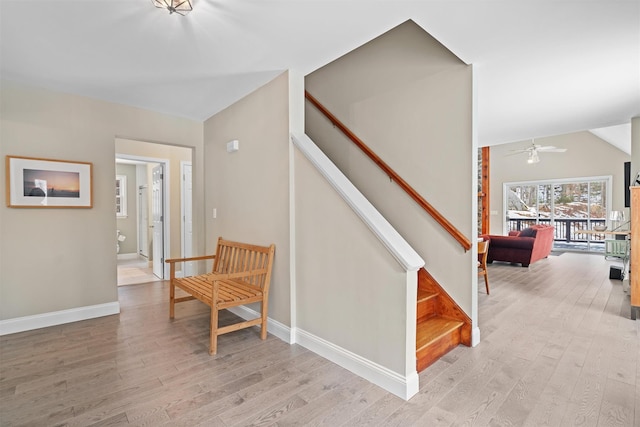 stairs with hardwood / wood-style flooring, lofted ceiling, and ceiling fan