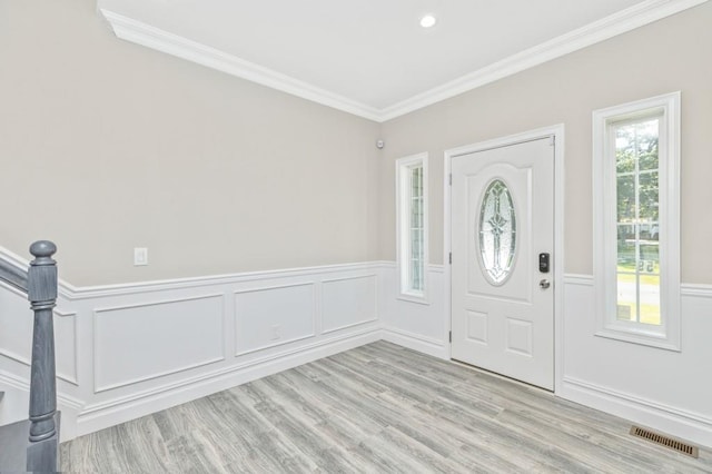 entryway featuring ornamental molding and light hardwood / wood-style flooring