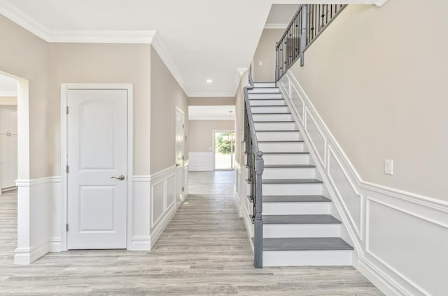 staircase with crown molding and wood-type flooring