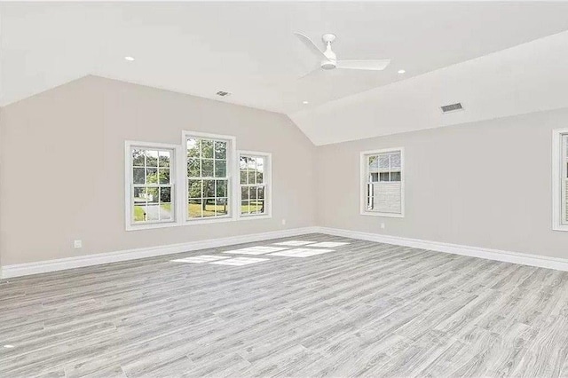 spare room featuring light hardwood / wood-style flooring, vaulted ceiling, and ceiling fan