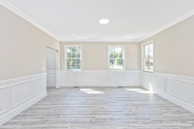 empty room with light hardwood / wood-style flooring and ornamental molding