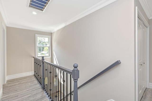 stairs featuring wood-type flooring and crown molding