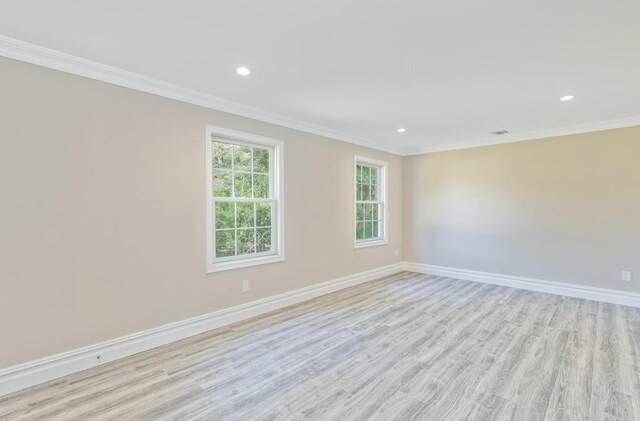 spare room featuring ornamental molding and light wood-type flooring