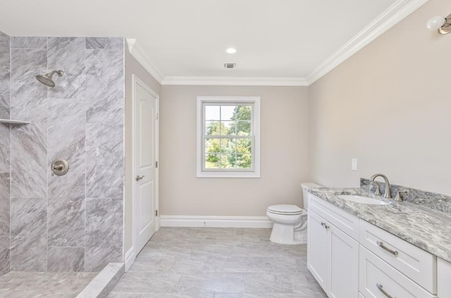 bathroom featuring vanity, toilet, ornamental molding, and a tile shower