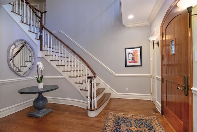 foyer entrance featuring crown molding and dark wood-type flooring