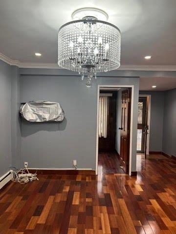 unfurnished dining area with ornamental molding, dark hardwood / wood-style floors, and a notable chandelier