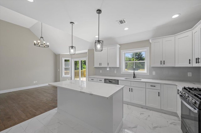 kitchen featuring black gas range, tasteful backsplash, white cabinetry, and sink