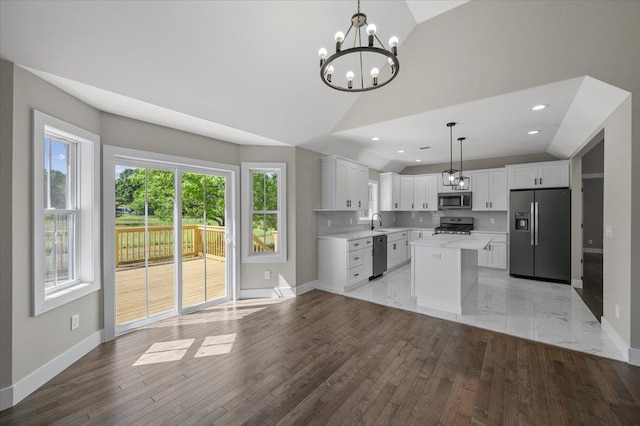 kitchen with white cabinetry, a center island, stainless steel appliances, and decorative light fixtures